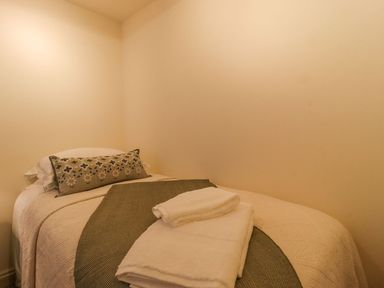 A bedroom with a bed and towels at Bridge House Cottage Burn Bridge near Harrogate