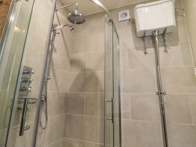 A shower setup with a glass enclosure and controls at Bridge House Cottage Burn Bridge near Harrogate