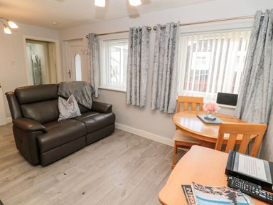 A living room with a sofa and table at Primrose Cottage in Chathill