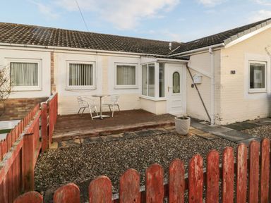 A house exterior with a patio and seating area at Primrose Cottage in Chathill