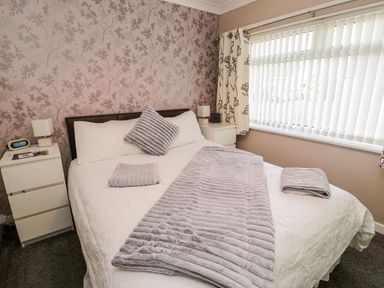 A bedroom with a bed and nightstands at Megstone in Chathill