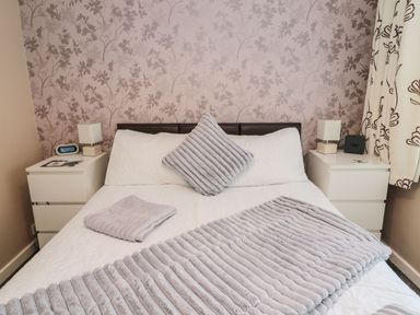 A bedroom with a bed and bedside tables at Megstone in Chathill