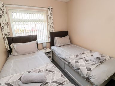 A bedroom with two single beds and a window at Megstone in Chathill