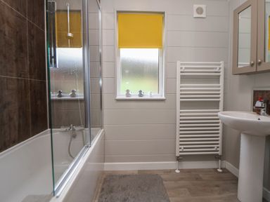 A bathroom with a bathtub and sink at Pine Lodge in Lloc near Caerwys