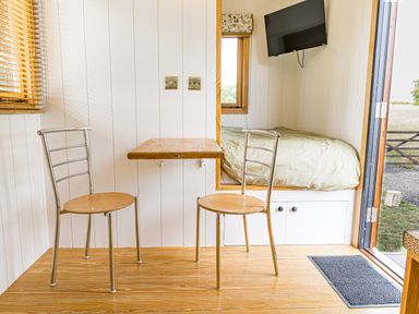 A sitting room with chairs and a table at No 2 The Parkland in Upton Warren
