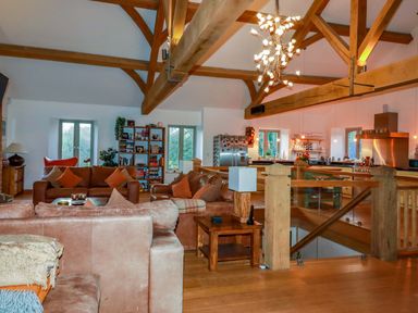 A living room with a sofa and bookshelf at Kerslake House in Crafthole