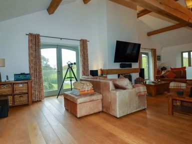 A living room with a sofa and a television at Kerslake House in Crafthole