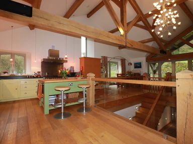 A kitchen with a large island and bar stools at Kerslake House Crafthole