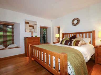 A bedroom with wooden furniture and a bed at Kerslake House Crafthole