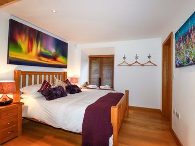 A bedroom with a bed and artwork on the wall at Kerslake House Crafthole