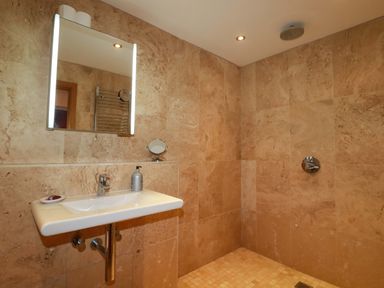 A bathroom with a sink, mirror, and shower at Kerslake House Crafthole