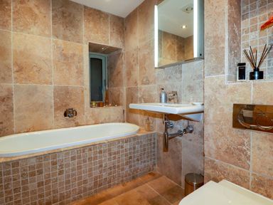 A bathroom with a bathtub, sink, and toilet at Kerslake House in Crafthole