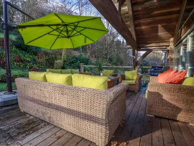 An outdoor living area with sofas and an umbrella at Kerslake House Crafthole