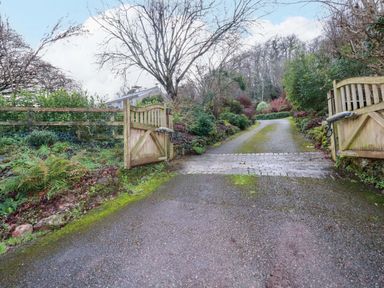 A gate leading to a driveway surrounded by greenery at Kerslake House in Crafthole