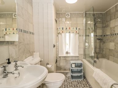 A bathroom with a sink toilet bathtub and shower at Honey Bee Cottage in Staintondale