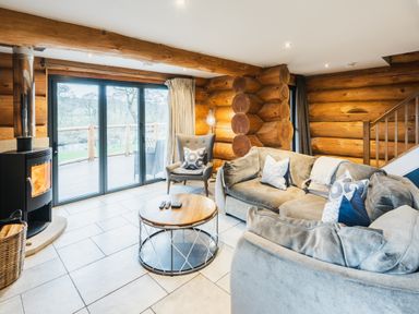 A living room with log walls and a coffee table at The Lookout in Addingham