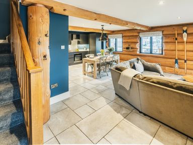 A living room with a staircase, sofa, dining table and kitchen cabinets at The Lookout in Addingham