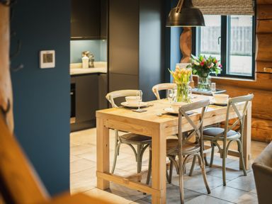 A dining area with wooden table and flowers at The Lookout in Addingham