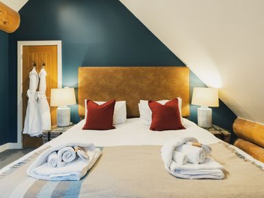 A bedroom with a bed and lamps at The Lookout in Addingham