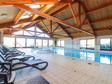 An indoor pool area with lounge chairs and a jacuzzi at Pentewan - 67 Portreath
