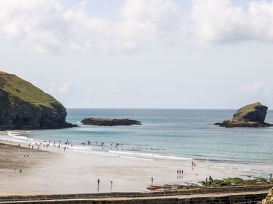 A beach with people walking and swimming at Pentewan - 67 Portreath