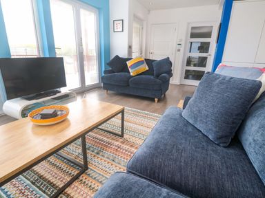 A living room with a television and a coffee table at Pentewan - 67 Portreath