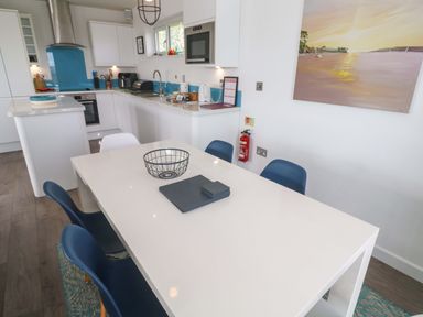 A kitchen with a dining table and chairs at Pentewan - 67 in Portreath