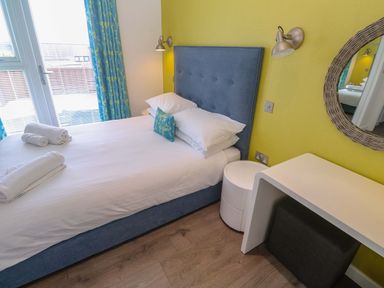 A bedroom with a bed and desk at Pentewan - 67 Portreath