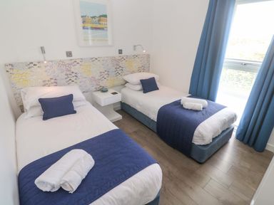 A bedroom with two single beds and a painting at Pentewan - 67 Portreath