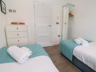 A bedroom with twin beds and a chest of drawers at Pentewan - 67 Portreath