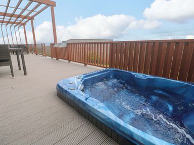 An outdoor space with a spa and seating area at Pentewan - 67 Portreath
