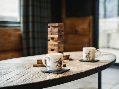 A living room with coffee cups and a wooden block game at Bears Den in Addingham