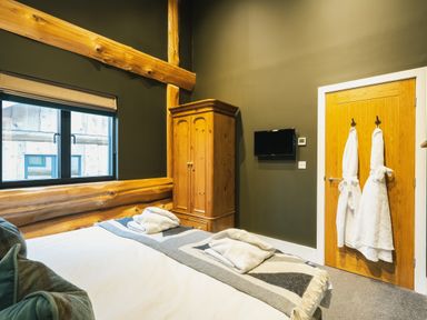 A bedroom with a bed and wardrobe at Bears Den in Addingham