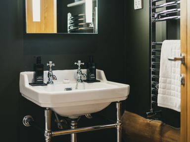 A bathroom with a sink and towel rack at Bears Den in Addingham