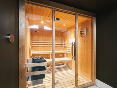 A sauna with wooden benches and a temperature control panel at Bears Den in Addingham