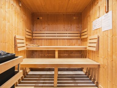 A sauna with wooden benches and a stone heater at Bears Den in Addingham