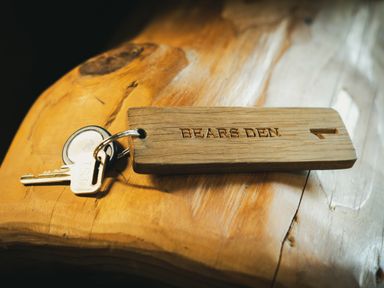 A key with a wooden tag labeled Bears Den