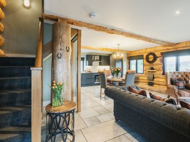 A living room with a staircase and kitchen area at Keepers Cabin in Addingham