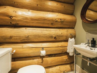 A bathroom with wooden walls and a toilet at Keepers Cabin in Addingham