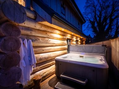 An outdoor hot tub next to wooden wall at Keepers Cabin Addingham