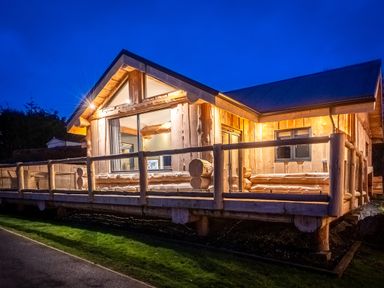 A wooden cabin with a deck and large windows at The Farmhouse in Addingham