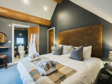 A bedroom with a bed and an adjoining bathroom at Apres Ski in Addingham