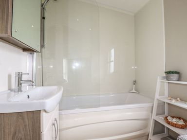 A bathroom with a tub and sink at No. 4 Fistral in Newquay