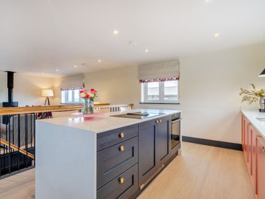 A kitchen with an island and cabinets at Bell House in Llanfechell