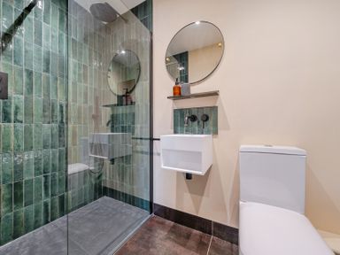 A bathroom with a shower, toilet, and sink at Bell House in Llanfechell