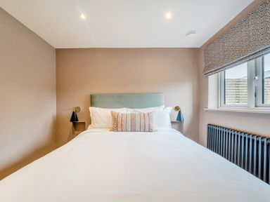 A bedroom with a bed and wall lamp at Bell House in Llanfechell