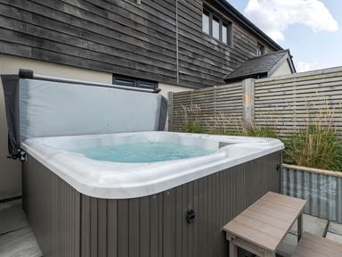 A hot tub with steps in an outdoor area at Bell House Llanfechell