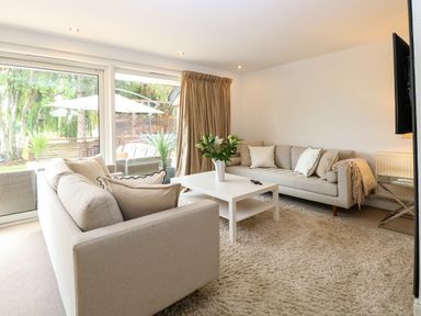 A living room with sofas, a coffee table, and a television at Three Ways South Lopham near Garboldisham