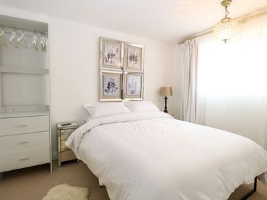 A bedroom with a bed and wardrobe at Three Ways South Lopham near Garboldisham