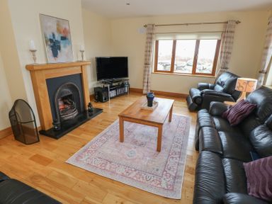 A living room with a fireplace and television at Tigh Marie 